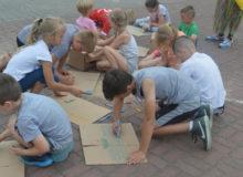 dzieci rysujące po kartonach
